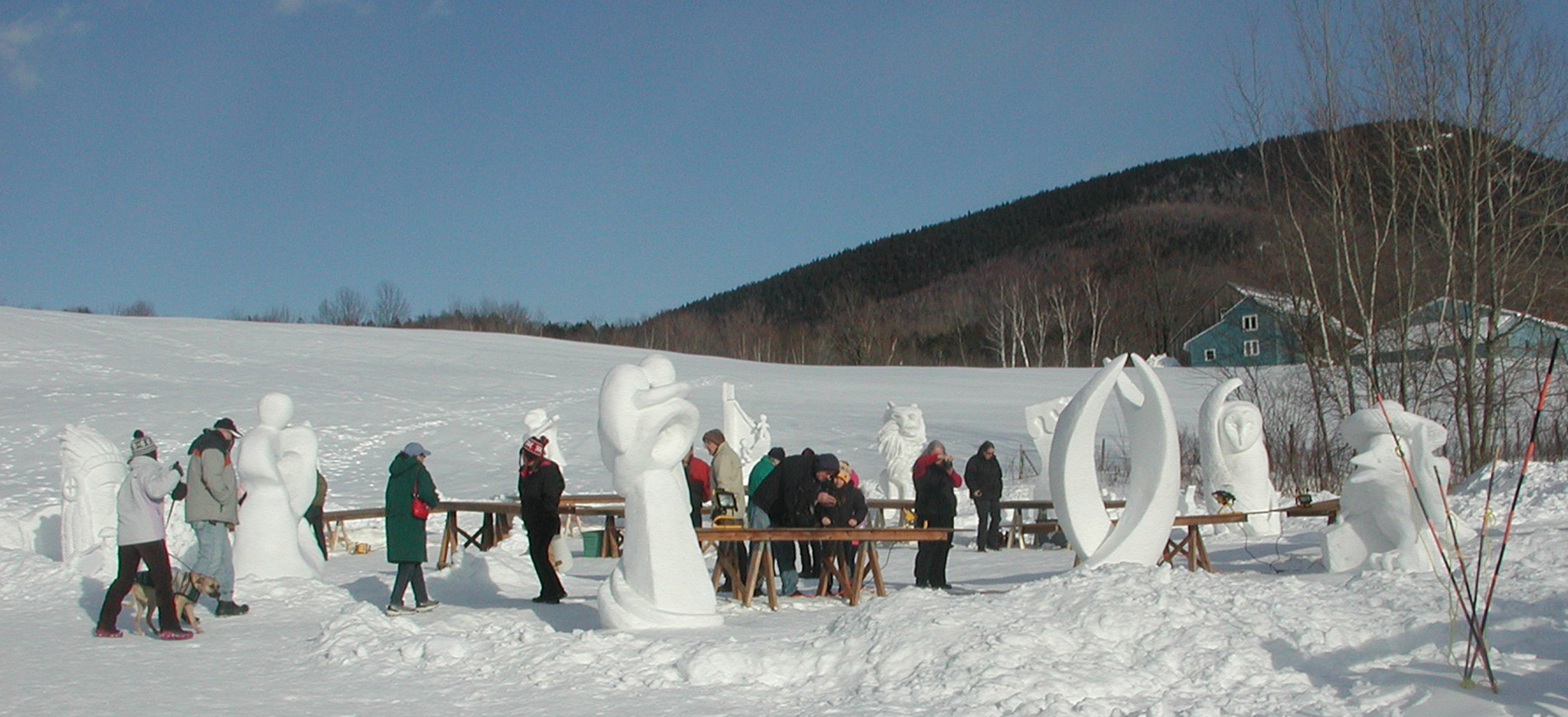 snow sculptors working on sculptures with mountain in background