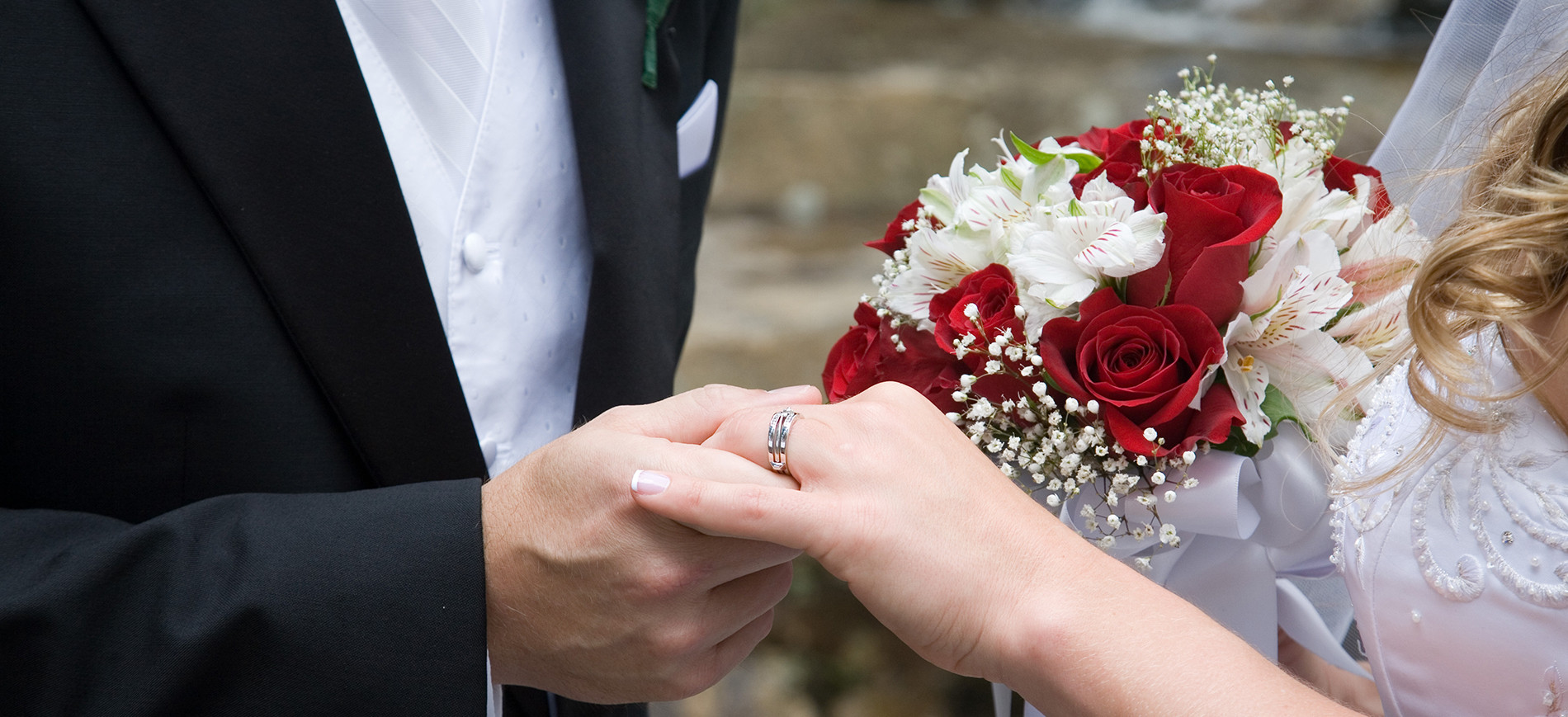 two hands with wedding rings & bouquet