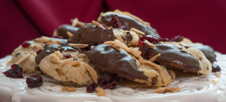 Holiday Delight Cookies dipped in chocolate on white stand with burgundy background