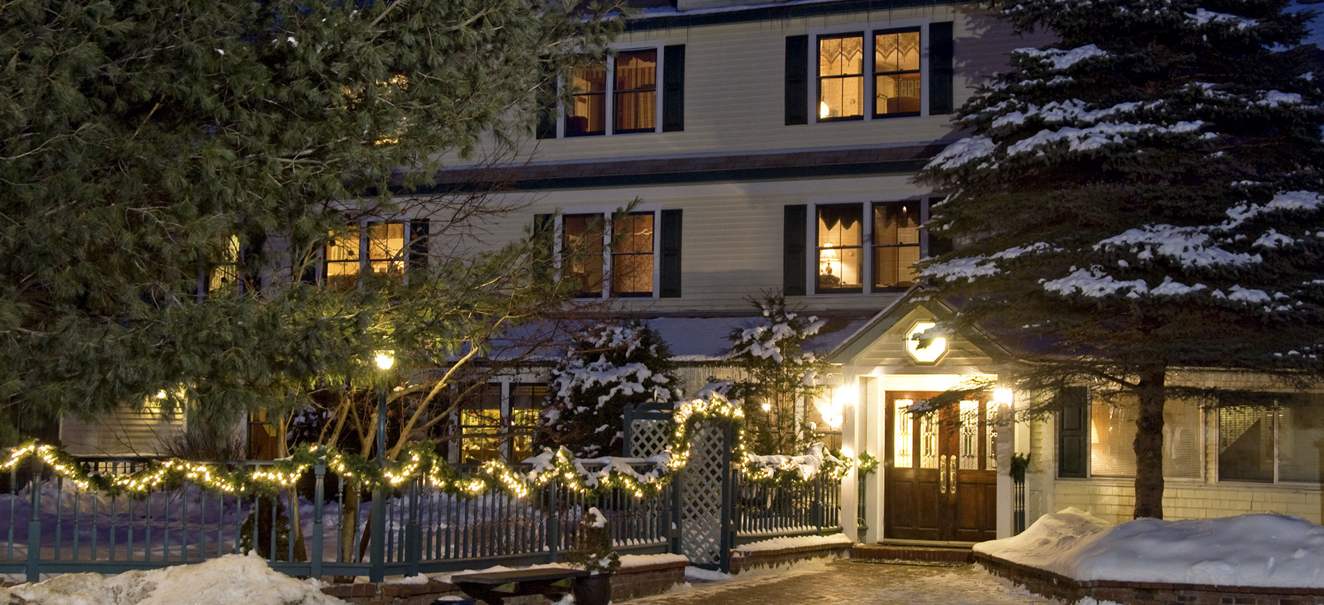 Inn at Ellis River entrance on winter night with snow