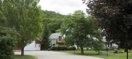 Entrance drive to Inn at Ellis River with Inn, red barn, cottage & trees