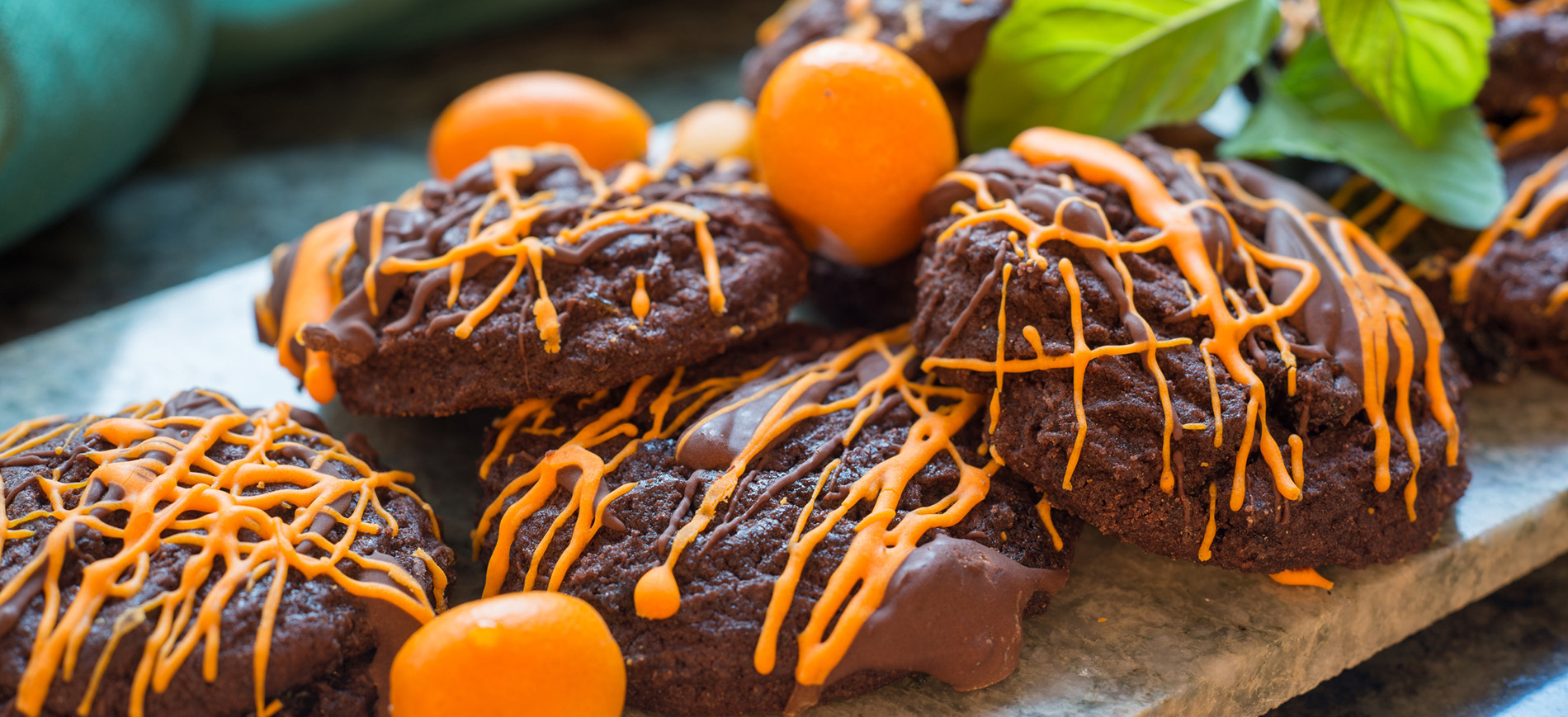 Spirited chocolate cookies with orange drizzle, kumquats & mint garnish