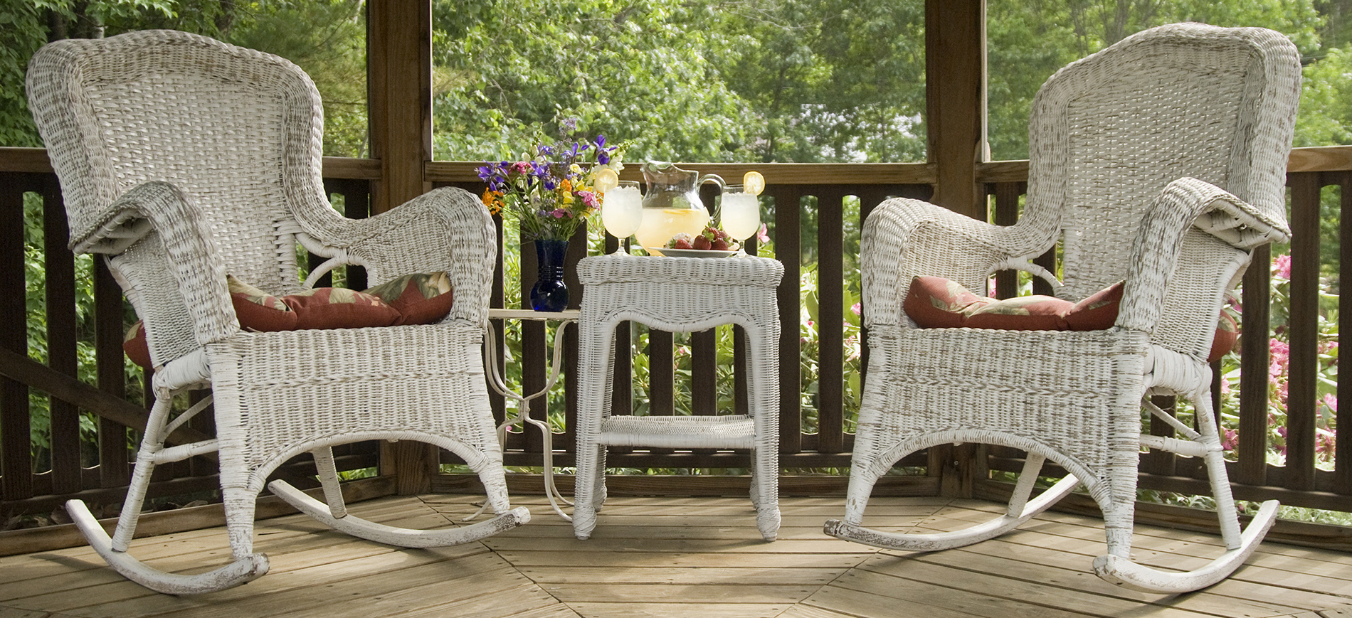 two white wicker rockers and table with lemonade in gazebo