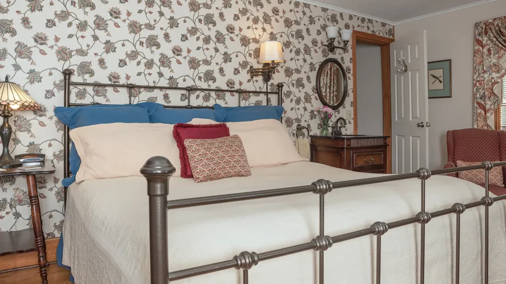 Dianas Baths - bed with view of sink and bathroom door.