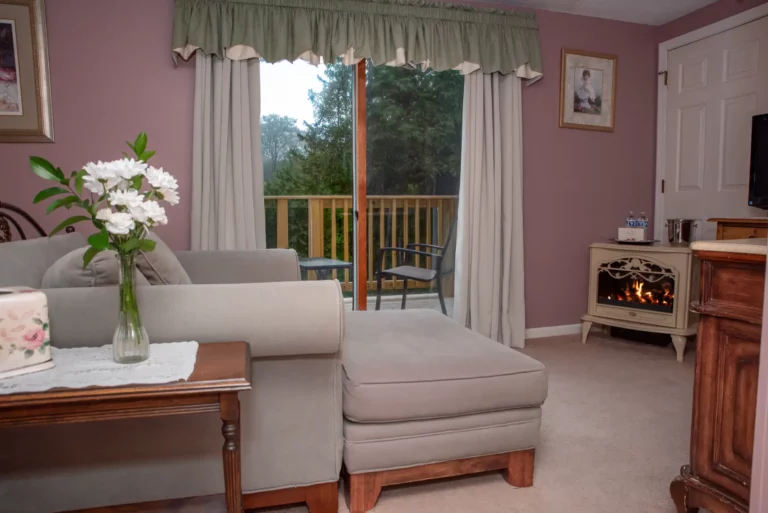 Beige armchair, ottoman, and view of purple exterior wall.