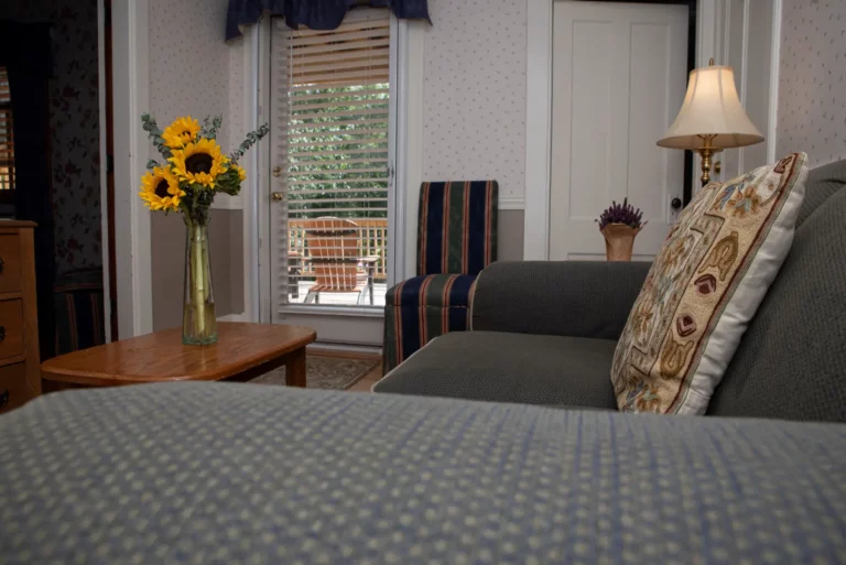 bedroom with gray quilted bed, sunflower vase.