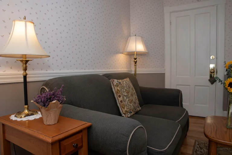 Living room with beige sofa, wooden side table, lamp,.