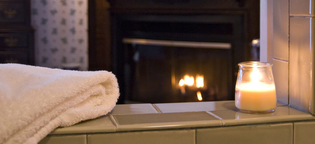 yellow tulips in glass vase with jetted tub behind