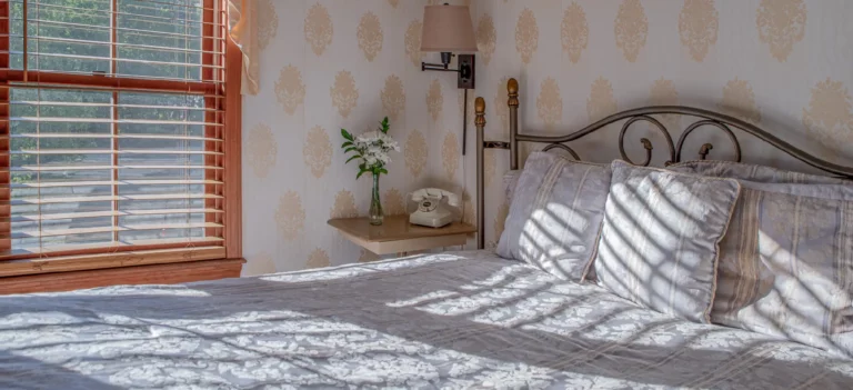Bedroom with a bed, headboard, and window with blinds.